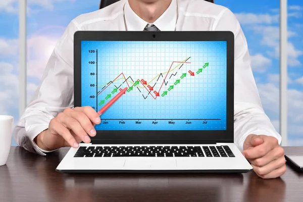 Trader sitting in office and pointing on screen laptop with profit chart — Stock Photo, Image