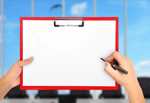 Hands drawing in blank red clipboard — Stock Photo, Image