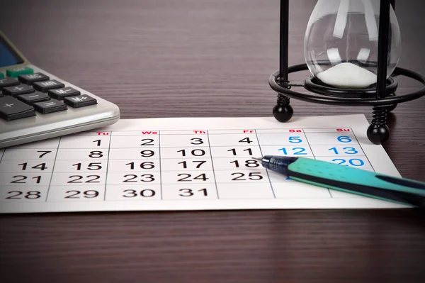 Página del calendario de negocios en la mesa, vidrio de arena, calculadora y pluma, primer plano —  Fotos de Stock