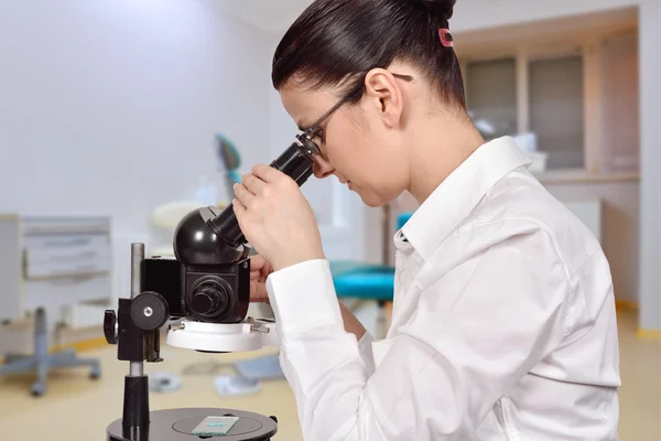 Female scientist looking through microscope — Stock Photo, Image