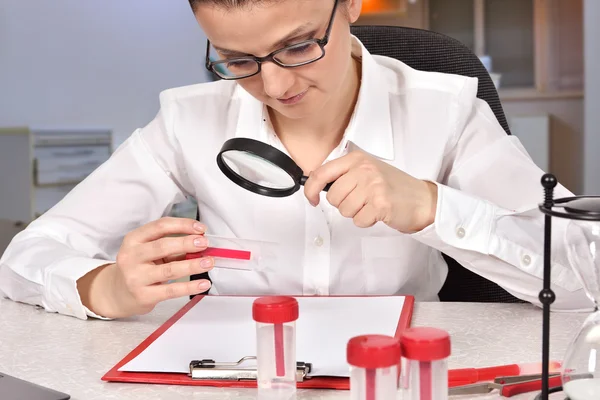 Woman scientist studying sample container — Stock Photo, Image