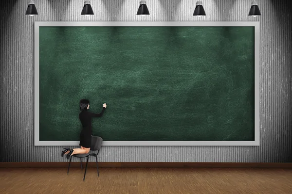 Vrouw tekenen op lege schoolbord — Stockfoto