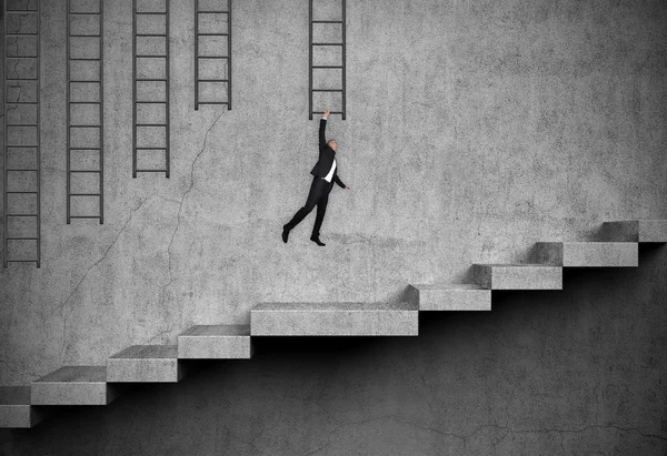 Homem de negócios pendurado na escada — Fotografia de Stock