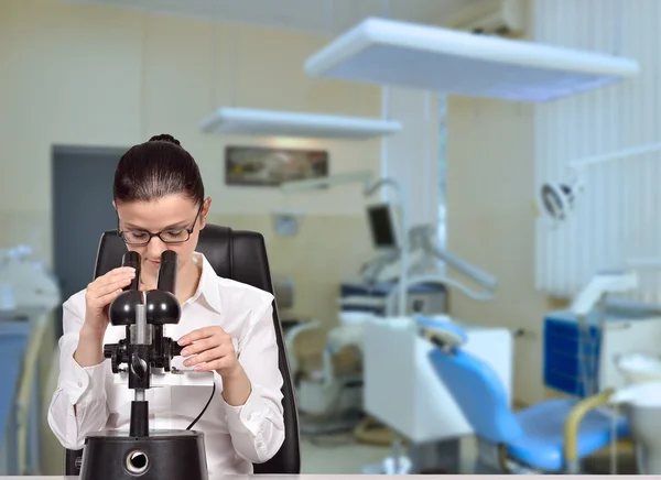 Vědec žena při pohledu přes mikroskop — Stock fotografie