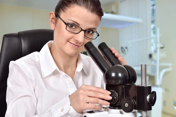 Female scientist looking through microscope — Stock Photo, Image
