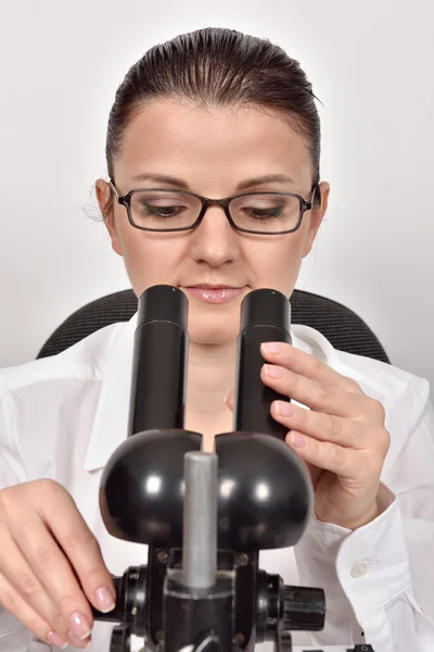 Female scientist looking through microscope — Stock Photo, Image