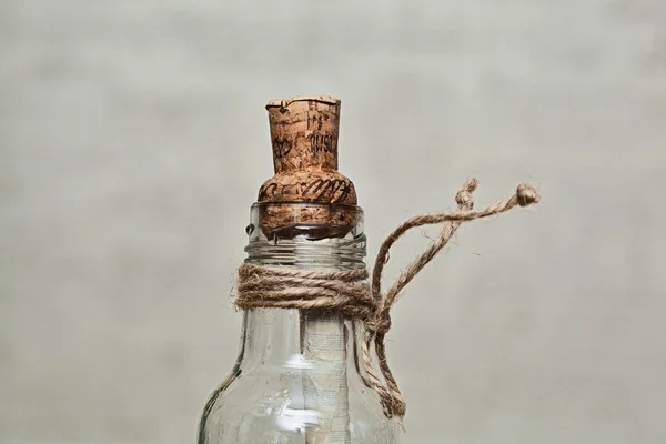 Декоративная винтажная бутылка с пробкой и запиской внутри на сером фоне — стоковое фото