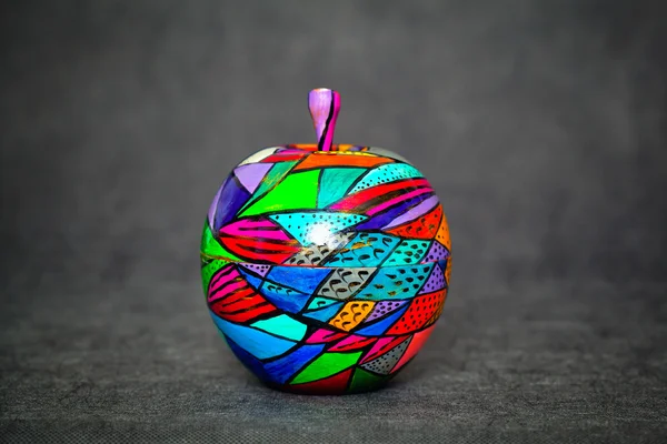 Manzana de madera decorativa sobre un fondo abstracto oscuro, colores pintados. tema hecho a mano —  Fotos de Stock