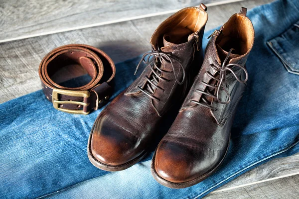 Zátiší oděvů - džíny, kožené boty a pásek s přezkou — Stock fotografie