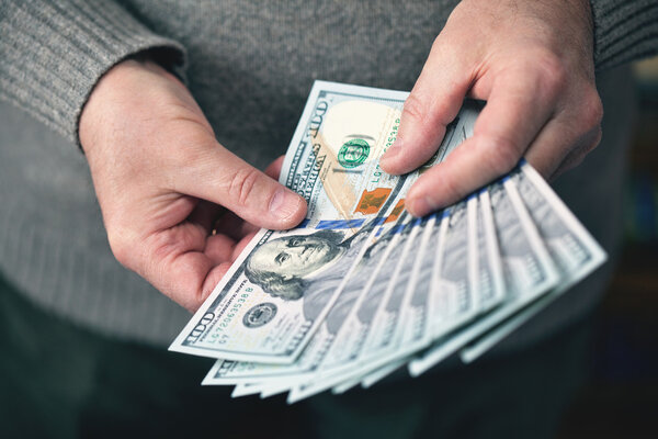 the man holding money dollars banknotes of one hundred