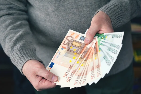Férfi kezében tartja a pénzt egy rajongó formájában. Pénz, az Euro (Eur) valuta bills — Stock Fotó