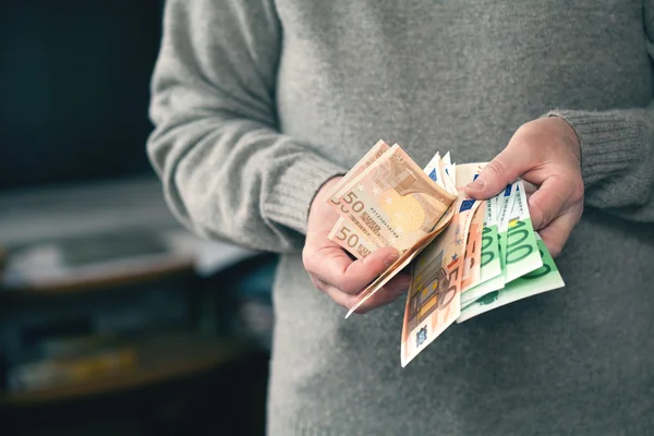 A férfi a lakásban számít pénz. az európai valuta - az Euro — Stock Fotó