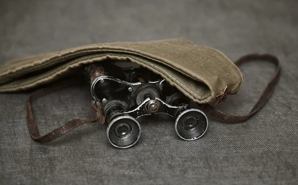 Military binoculars and a cap on a dark background, vintage style — Stock Photo, Image