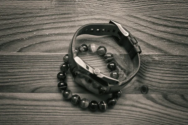 Armbanduhr und ein Armband aus Steinen an der Hand. Herrenmodeaccessoires auf Holzgrund. Armband aus einem Stein namens - königlicher Achat — Stockfoto