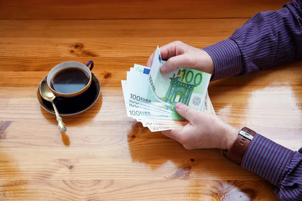 Üzleti ember úgy véli, Euro-bankjegyek és reggel kávét iszik — Stock Fotó