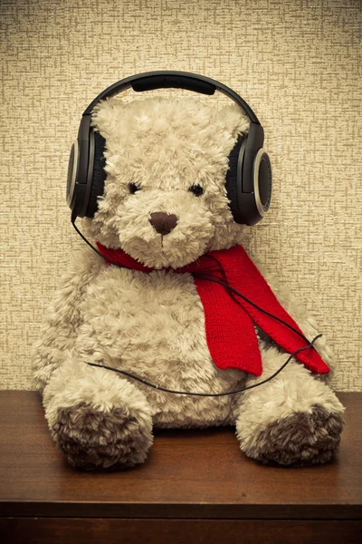 Urso retrô ouvindo música em fones de ouvido. foto tonificado amarelo — Fotografia de Stock