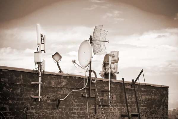 Satellite dishes on the roof. Photo toning in sepia — Stock Photo, Image