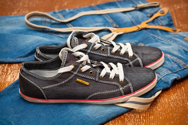 Zapatillas y jeans negros con tirantes —  Fotos de Stock