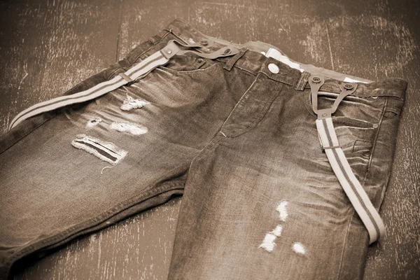 Löchrige Jeans mit Hosenträgern, Fototoning in Sepia — Stockfoto