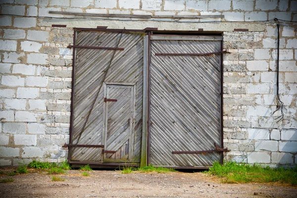 Large old wooden door in white stone building — Stock Photo, Image