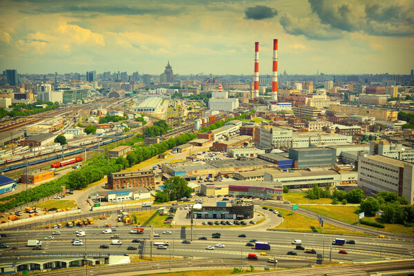 Cityscape of Moscow, Russia. Industrial Area, road with cars in the foreground. Photo tinted in yellow