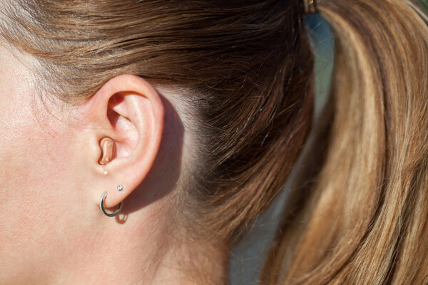 Hearing aid in the ear close up. Modern-ear hearing instruments