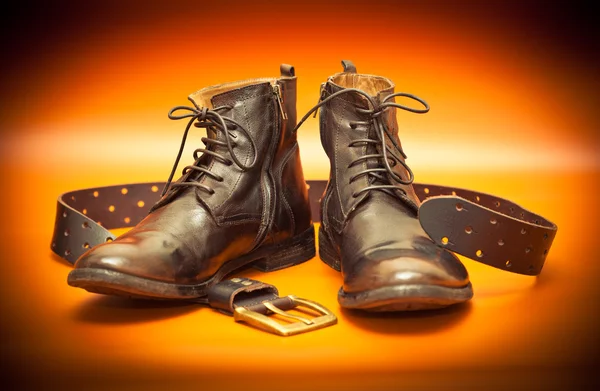 Men's leather shoes and a leather belt with a buckle.Photo toned in yellow — Stock Photo, Image