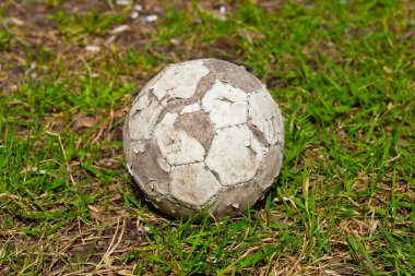 Çimenlerin üzerinde eski futbol topu