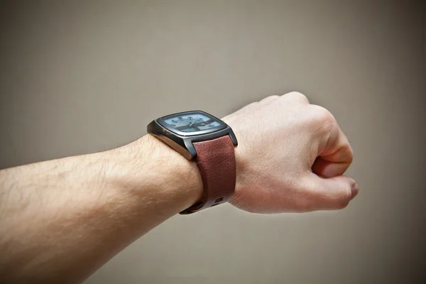 Жорстока рука людини з наручним годинником на сірому фоні — стокове фото