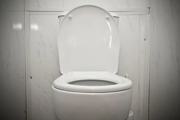 Goedkope witte toilet in een badkamer — Stockfoto