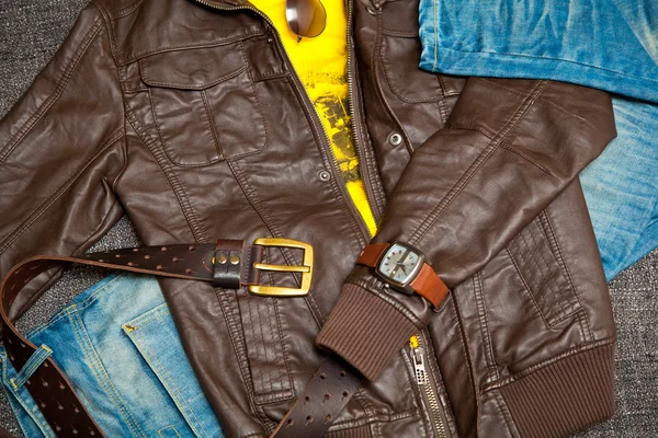 Set de moda para jóvenes. chaqueta de cuero, jeans con cinturón, camisa, relojes y gafas de sol — Foto de Stock