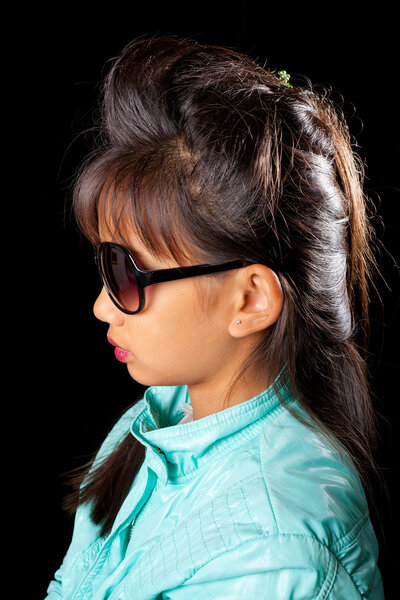 Beautiful tanned girl in sunglasses and fashionable hairstyle. Girl with Asian appearance