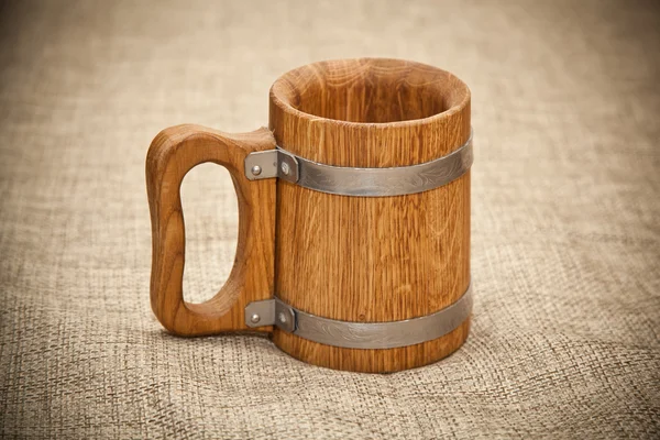 Large wooden mug on sacking — Stock Photo, Image