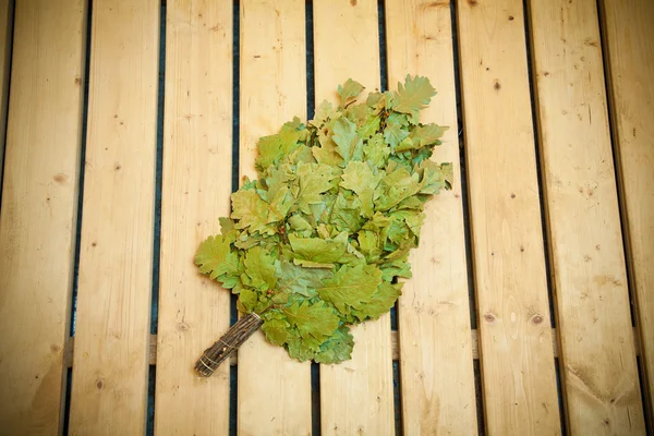 Oak broom on wooden boards for baths and saunas — Stock Photo, Image