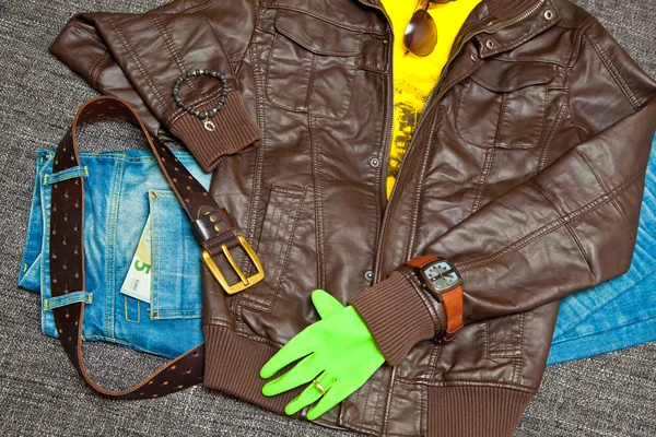 Traje de moda: chaqueta de cuero, camiseta, jeans con cinturón de cuero, relojes, pulseras, gafas de sol y guantes. Billete 5 euros — Foto de Stock