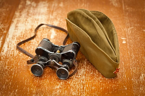 Military binoculars, forage cap with a red star. Victory Day on May 9. Retro style — Stock Photo, Image