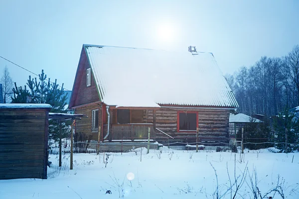 Casa de madera en la nieve en el pueblo, clima invernal —  Fotos de Stock