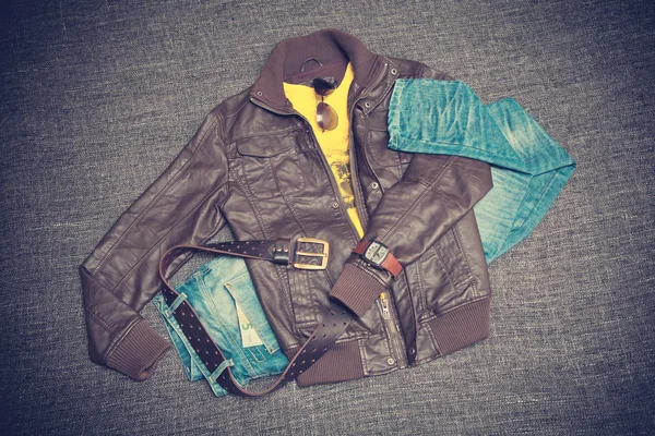 Stad jeugd mode kleding. Bruine jas, blue jeans, T-shirt, riem, horloges en zonnebril — Stockfoto