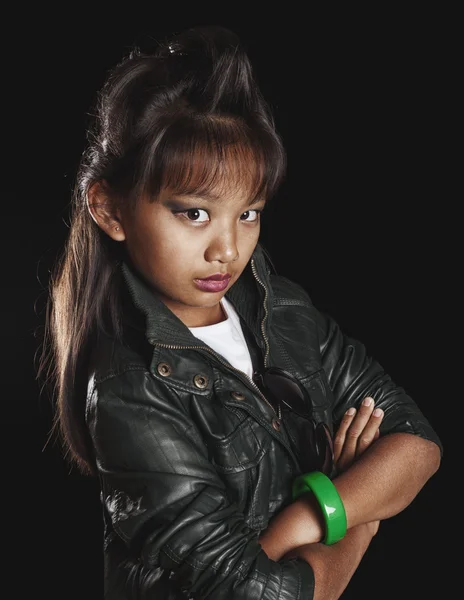 Powerful Asian girl with trendy rock hairstyle, in a leather jacket on a black background — Stock Photo, Image