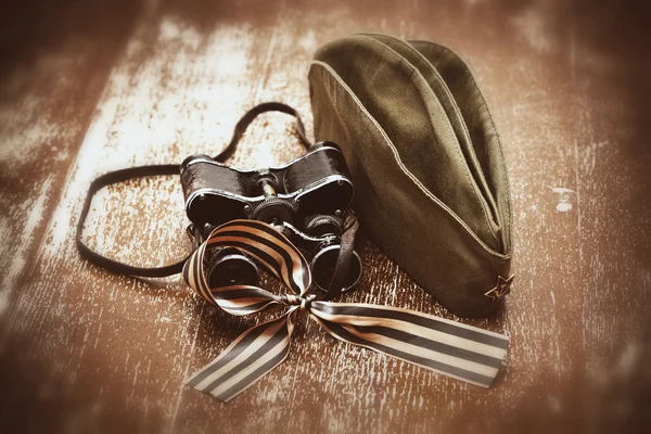 Солдатская полевая шапочка, военный бинокль, Георгиевская лента . Лицензионные Стоковые Изображения