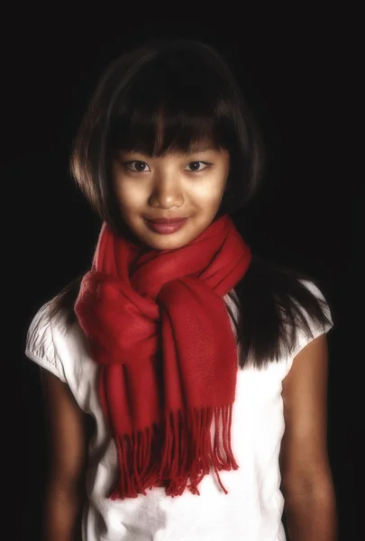 Hermosa chica morena en una bufanda roja alrededor de su cuello sobre un fondo negro —  Fotos de Stock