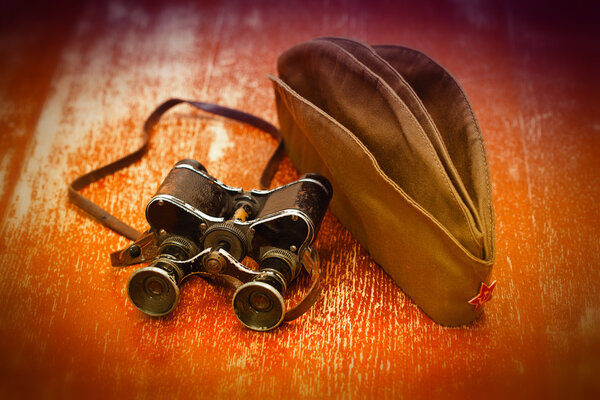 Items WWII: military binoculars, soldier field cap. May 9 Victory Day.