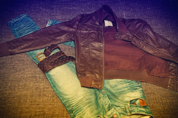 Модная молодежная одежда: джинсы, кожаная куртка, кожаный пояс. Фото выдержано в желтом и фиолетовом — стоковое фото