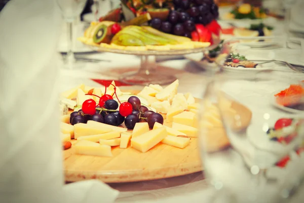 Covered table in the restaurant - cheese plate, fruit plate