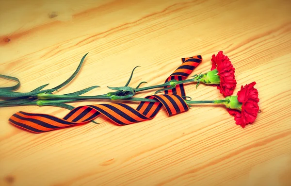 Flores de clavel y George Ribbon - un símbolo de la Victoria en la Gran Guerra Patria. Celebrar la victoria del 9 de mayo — Foto de Stock