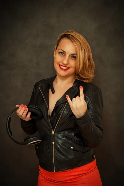 Happy girl in leather jacket and red skirt showing thumbs metal goat — Stock Photo, Image