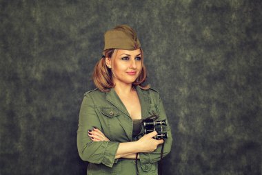 Garrison kap karanlık bir arka plan üzerinde İkinci Dünya Savaşı beri askeri dürbün ile gülümseyen bir kız. 9 Mayıs Zafer Bayramı için hazırlama.