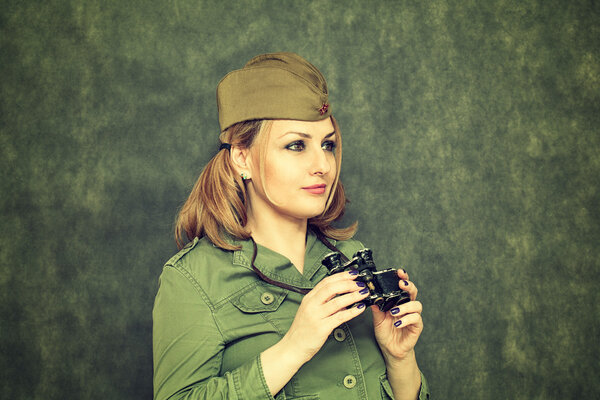 Девушка в военной одежде, в кепке, с биноклем. День Победы 9 мая
.