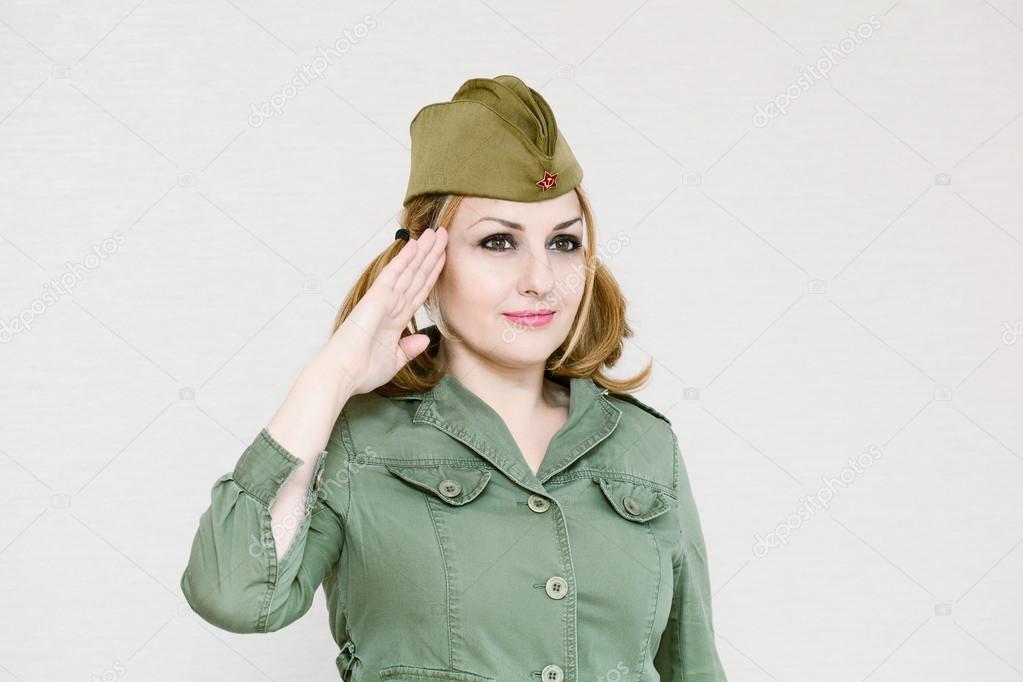 Woman in uniform gives military salute. Girl in garrison cap. In honor of Victory Day on May 9.