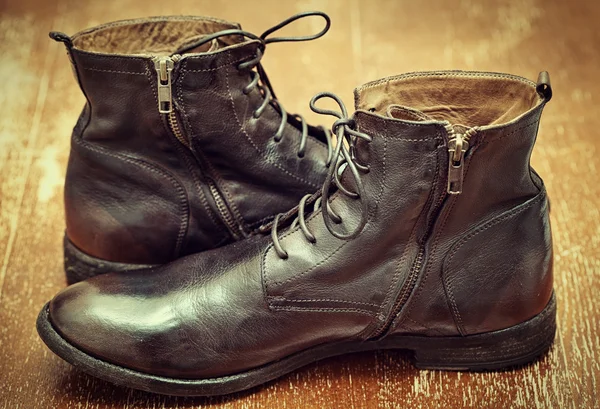 Damenstiefel aus braunem Leder im Vintage-Stil auf alter Holzoberfläche — Stockfoto